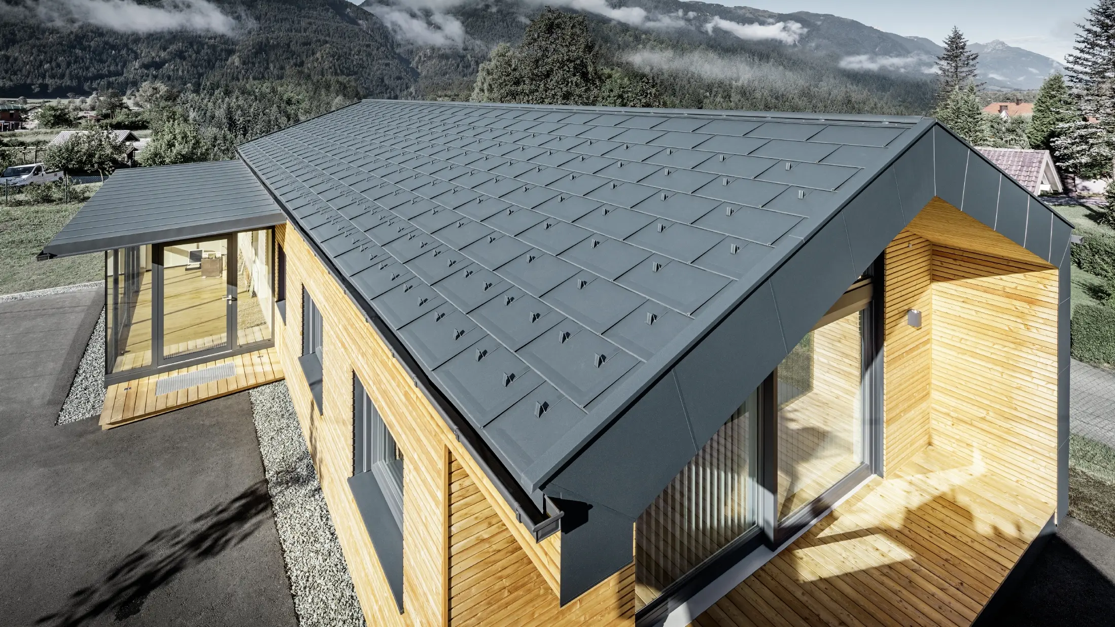 Noua clădire de birouri a Holzbau Faltheiner cu fațadă din lemn de larice, suprafețe vitrate generoase și un acoperiș din aluminiu PREFA în culoarea antracit.