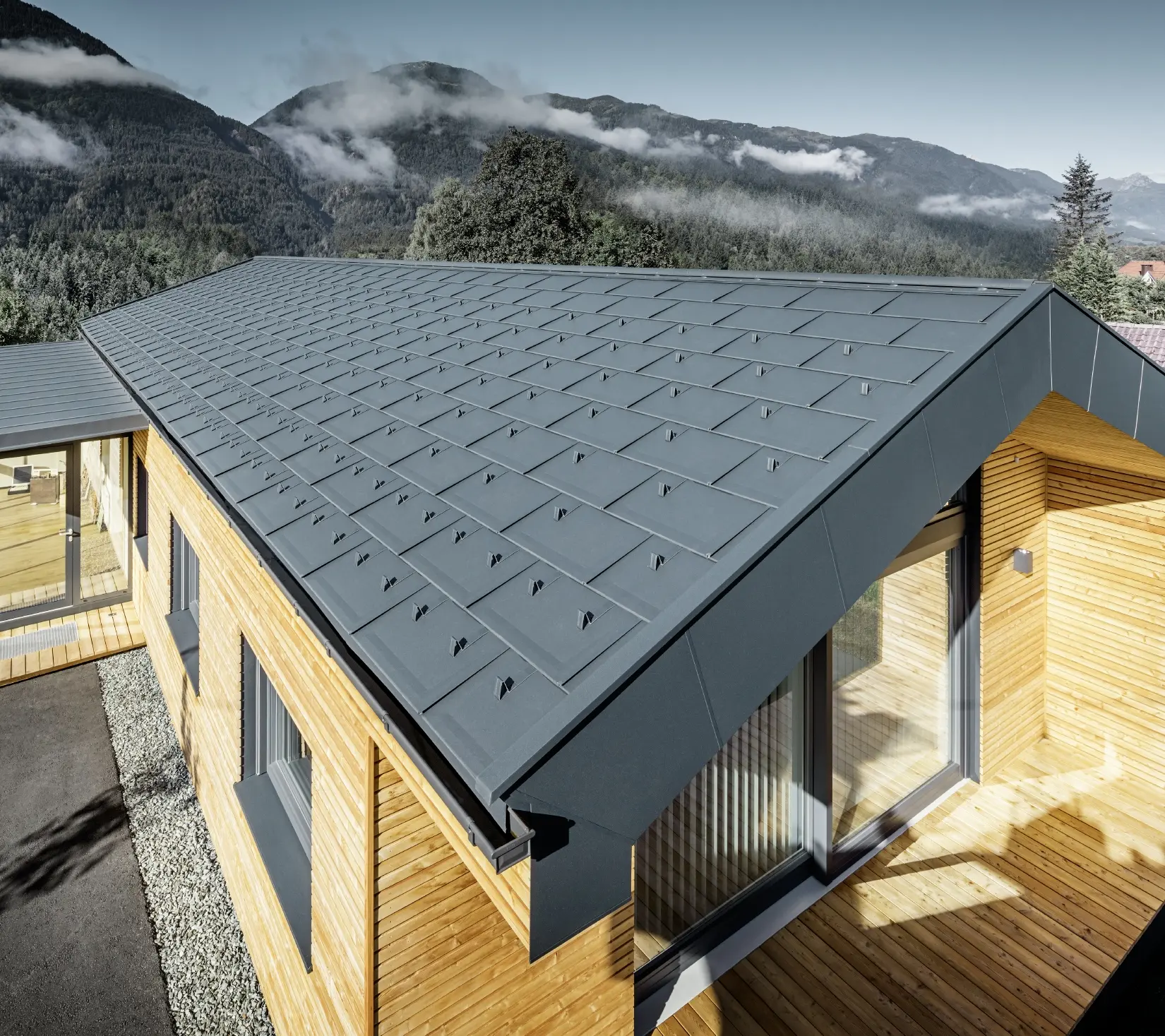 Noua clădire de birouri a Holzbau Faltheiner cu fațadă din lemn de larice, suprafețe vitrate generoase și un acoperiș din aluminiu PREFA în culoarea antracit.