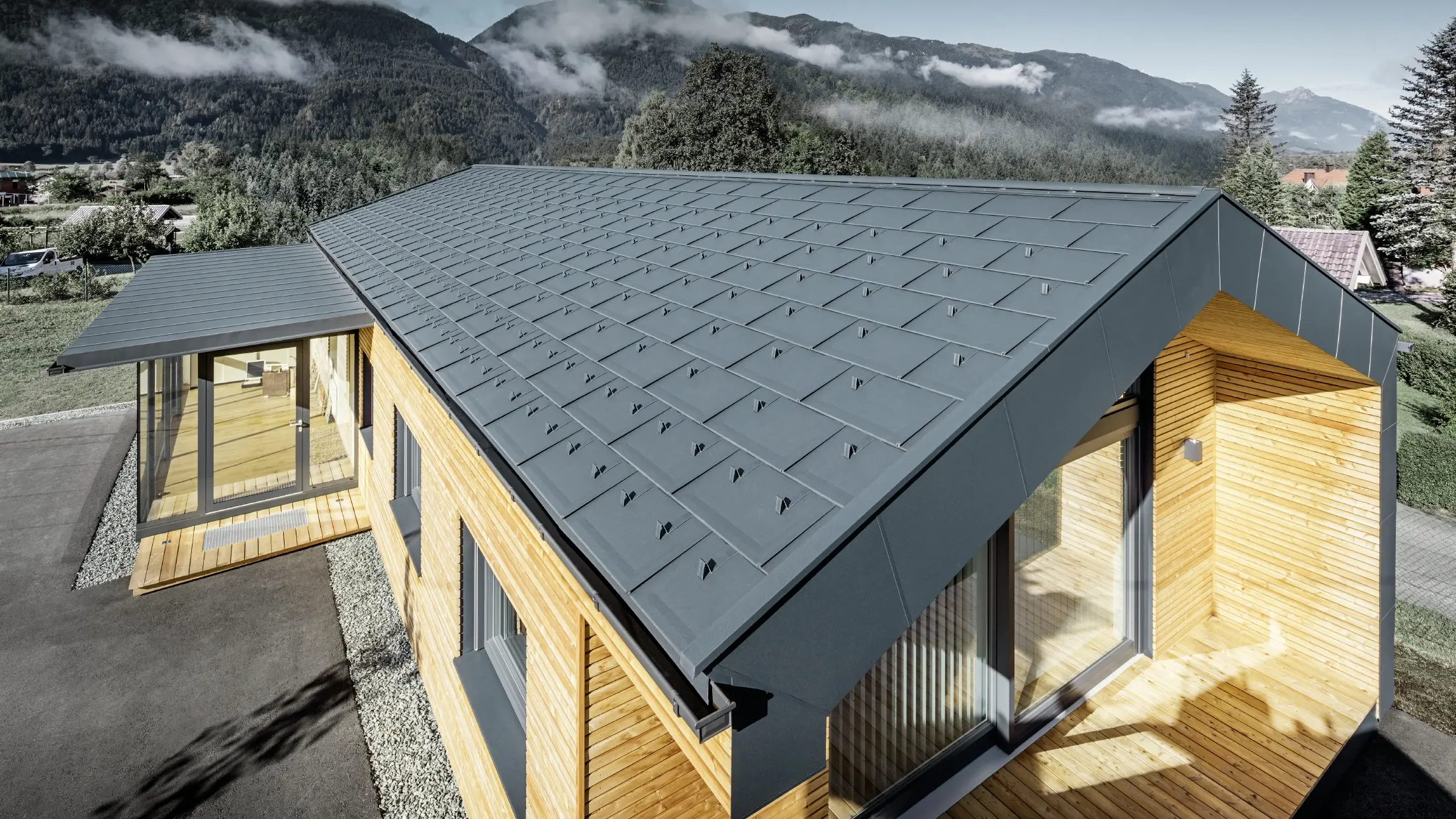 Noua clădire de birouri a Holzbau Faltheiner cu fațadă din lemn de larice, suprafețe vitrate generoase și un acoperiș din aluminiu PREFA în culoarea antracit.