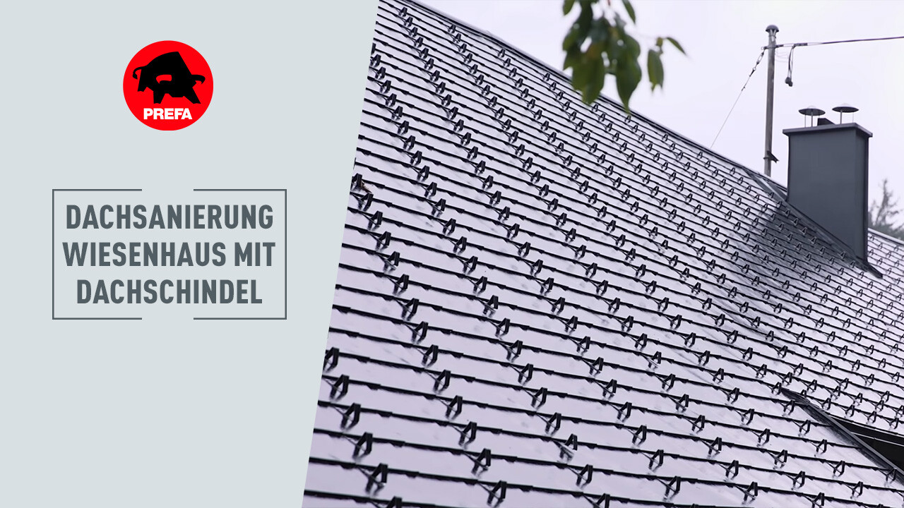 În prim-planul imaginii se vede un bărbat cu tricou alb, care explică ceva. În fundal se poate vedea casa. O casă veche de 400 de ani, la care acoperișul a fost renovat cu șindrilă PREFA în culoarea P.10.