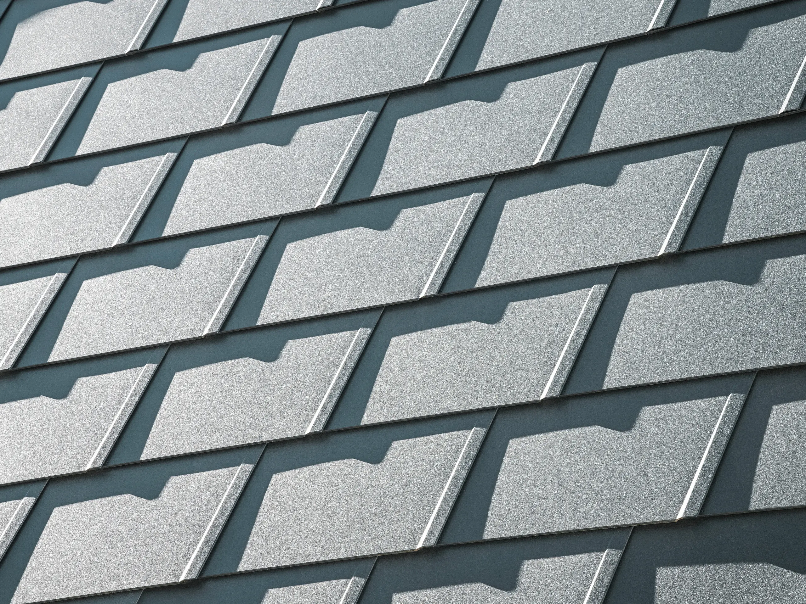 Detailansicht der PREFA Dachschindeln DS.19 in P.10 Anthrazit auf einem Einfamilienhaus in Mechernich. Die langlebigen Dachschindeln aus Aluminium bieten optimalen Schutz vor Witterungseinflüssen und sorgen für eine moderne, ästhetische Dachgestaltung. 