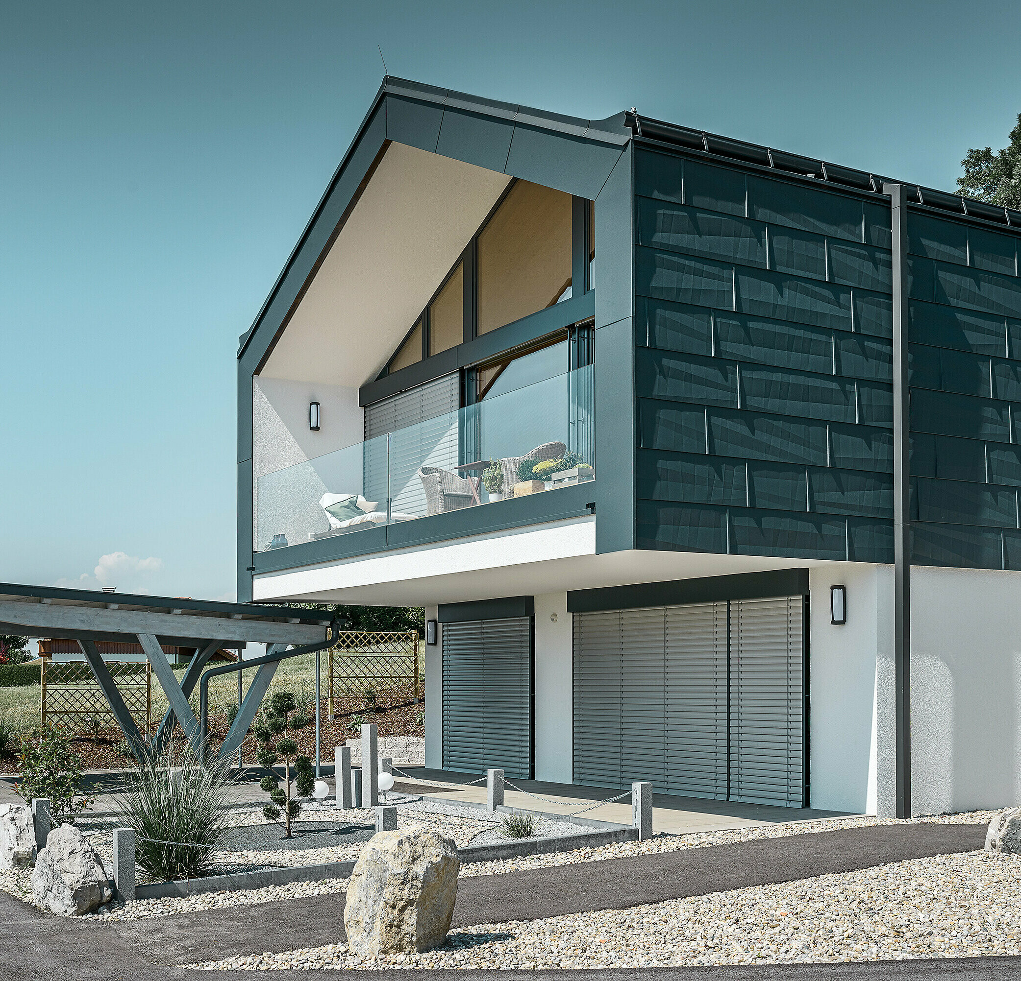 Placarea fațadei etajului cu panoul pentru fațade PREFA FX.12 în culoarea P.10 antracit. Ca burlan servește robustul burlan dreptunghiular PREFA.