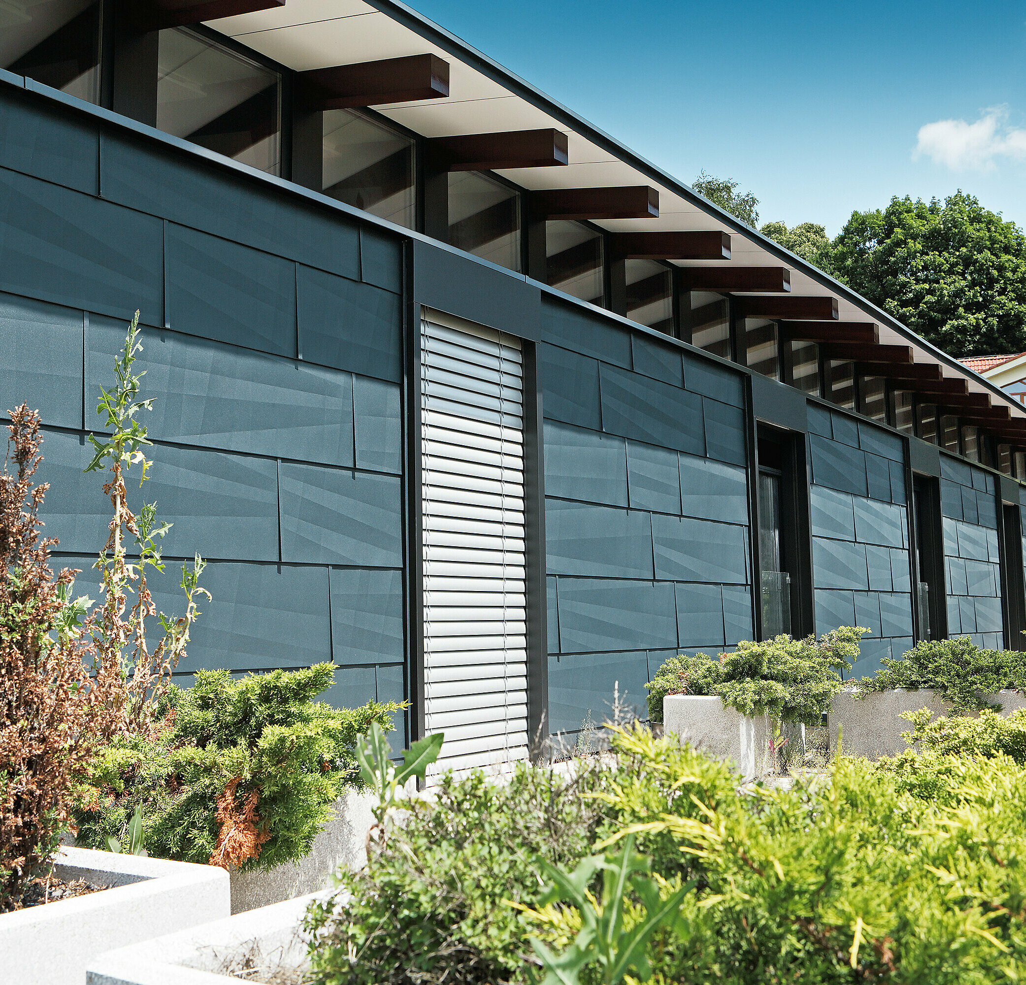 Parte expusă intemperiilor cu design modern, cu panoul pentru fațadă FX.12 în culoarea antracit, cu grădina.