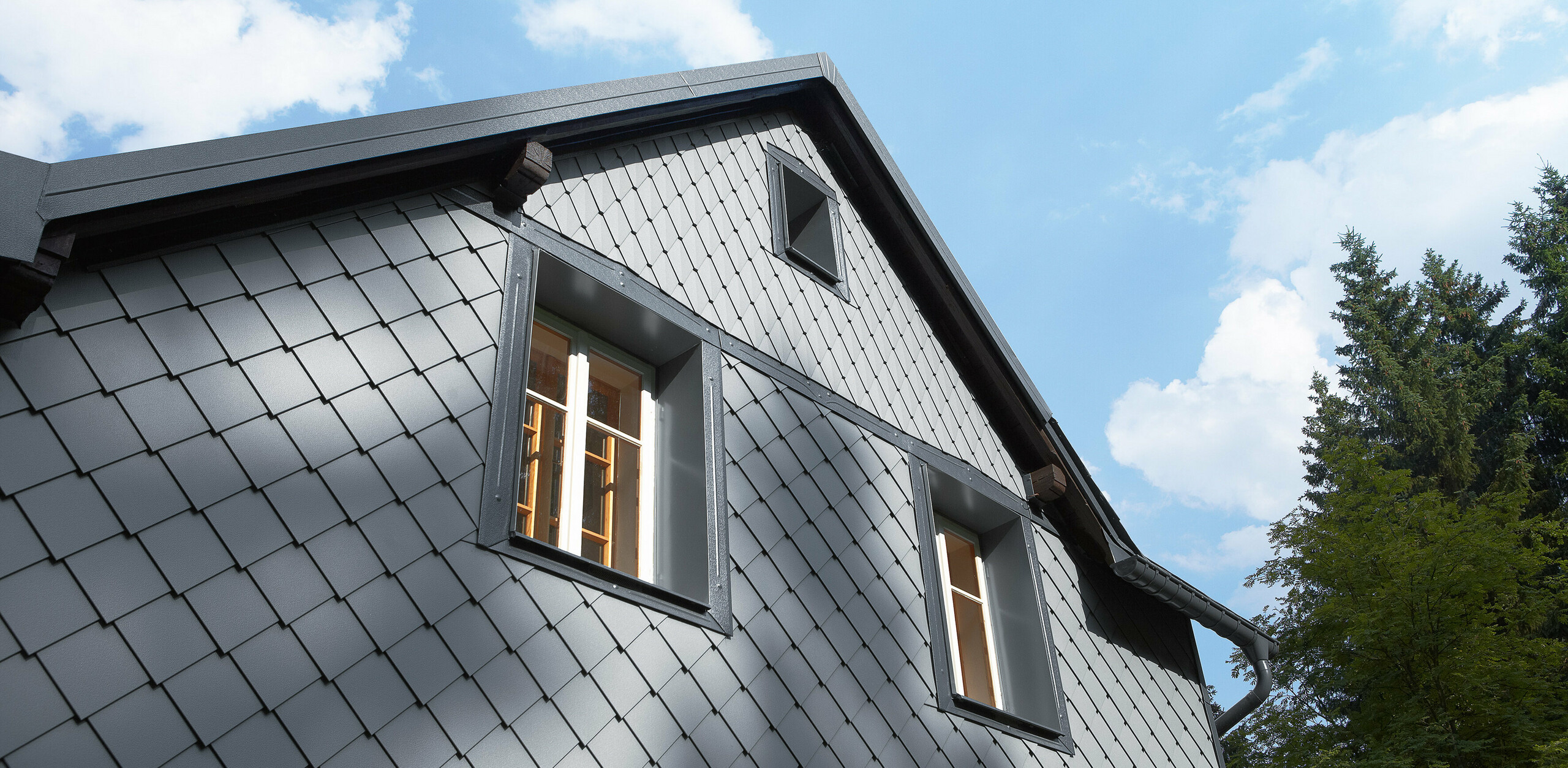 Partea expusă intemperiilor placată cu solzii romboidali pentru fațadă 20 × 20 și solzi romboidali mici pe fațada de la PREFA