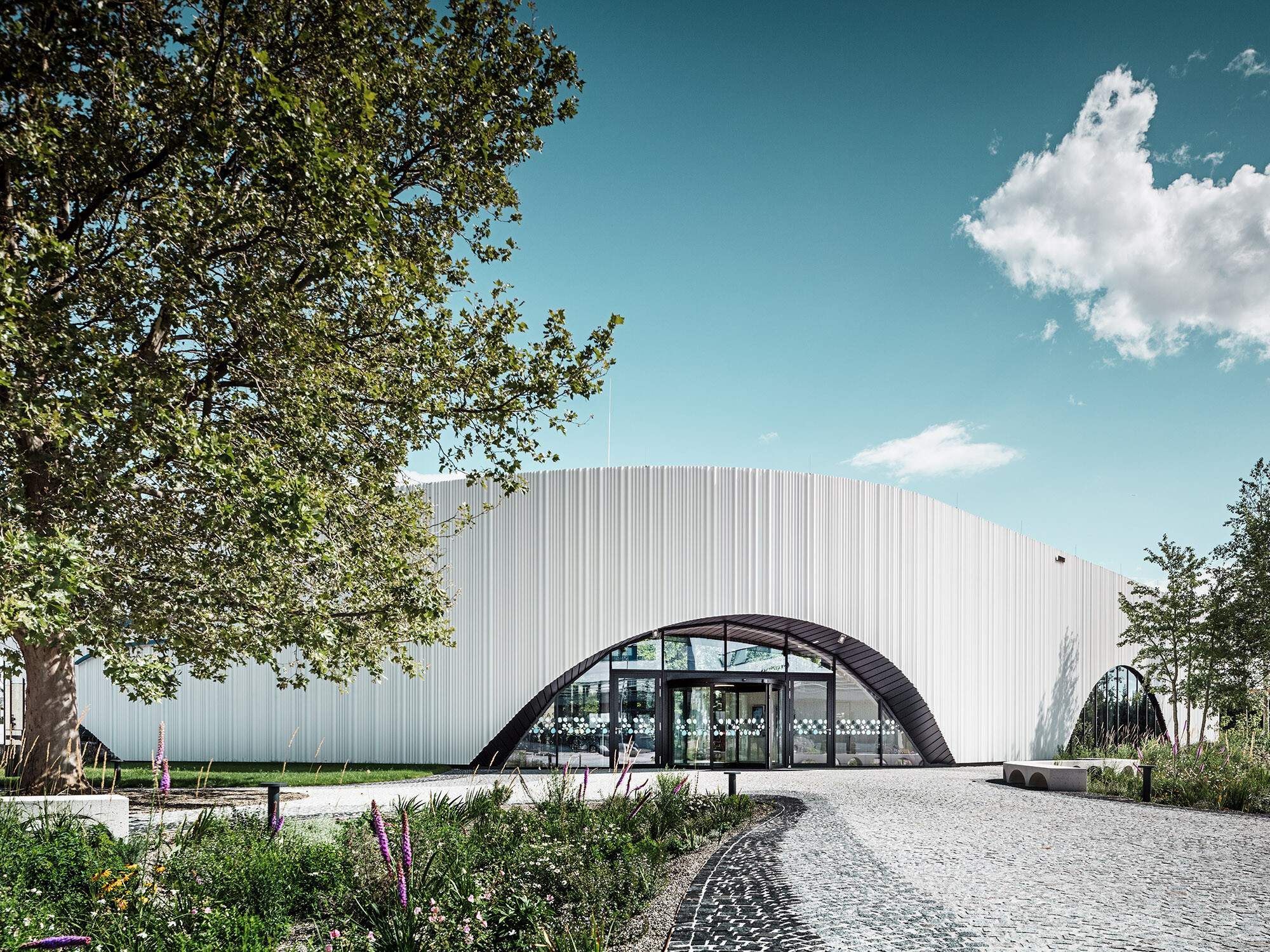 O vedere normală a Restaurantului Walters cu una dintre ferestrele sale semicirculare, într-un mediu verde.