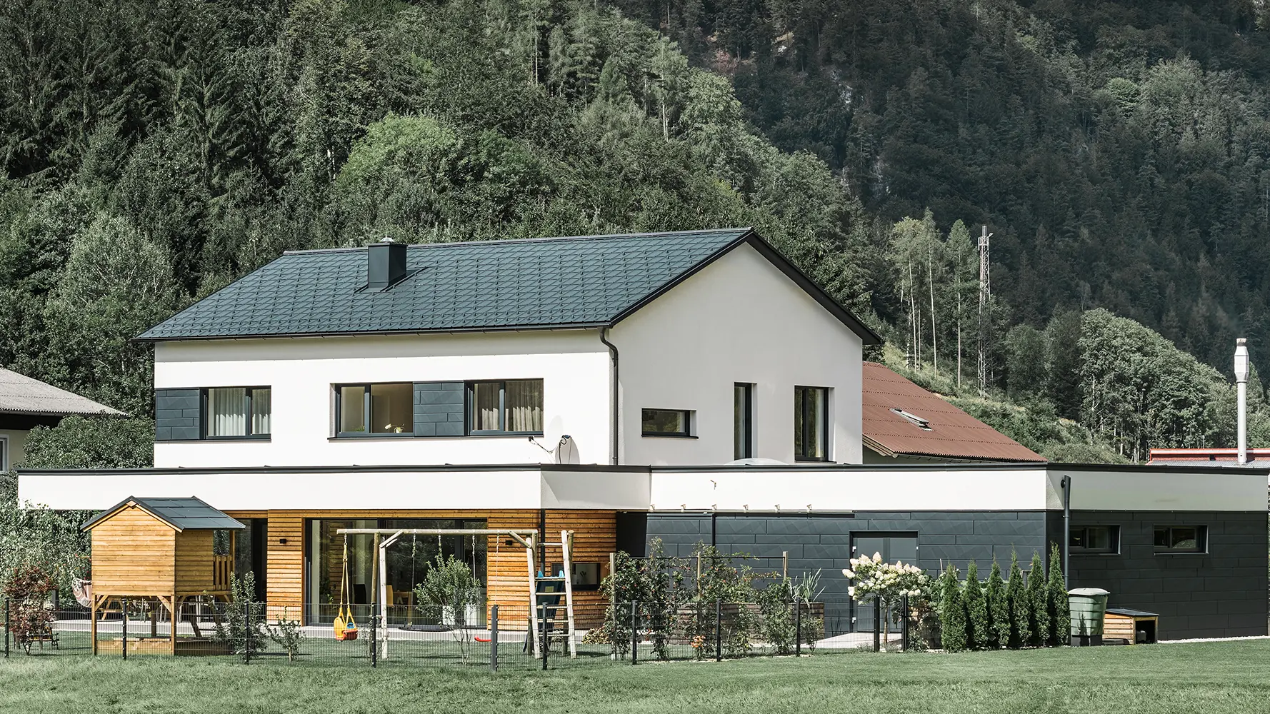 Casă monofamilială, construcție nouă, cu fațadă din lemn de larice în combinație cu PREFA Siding.X în culoarea antracit.