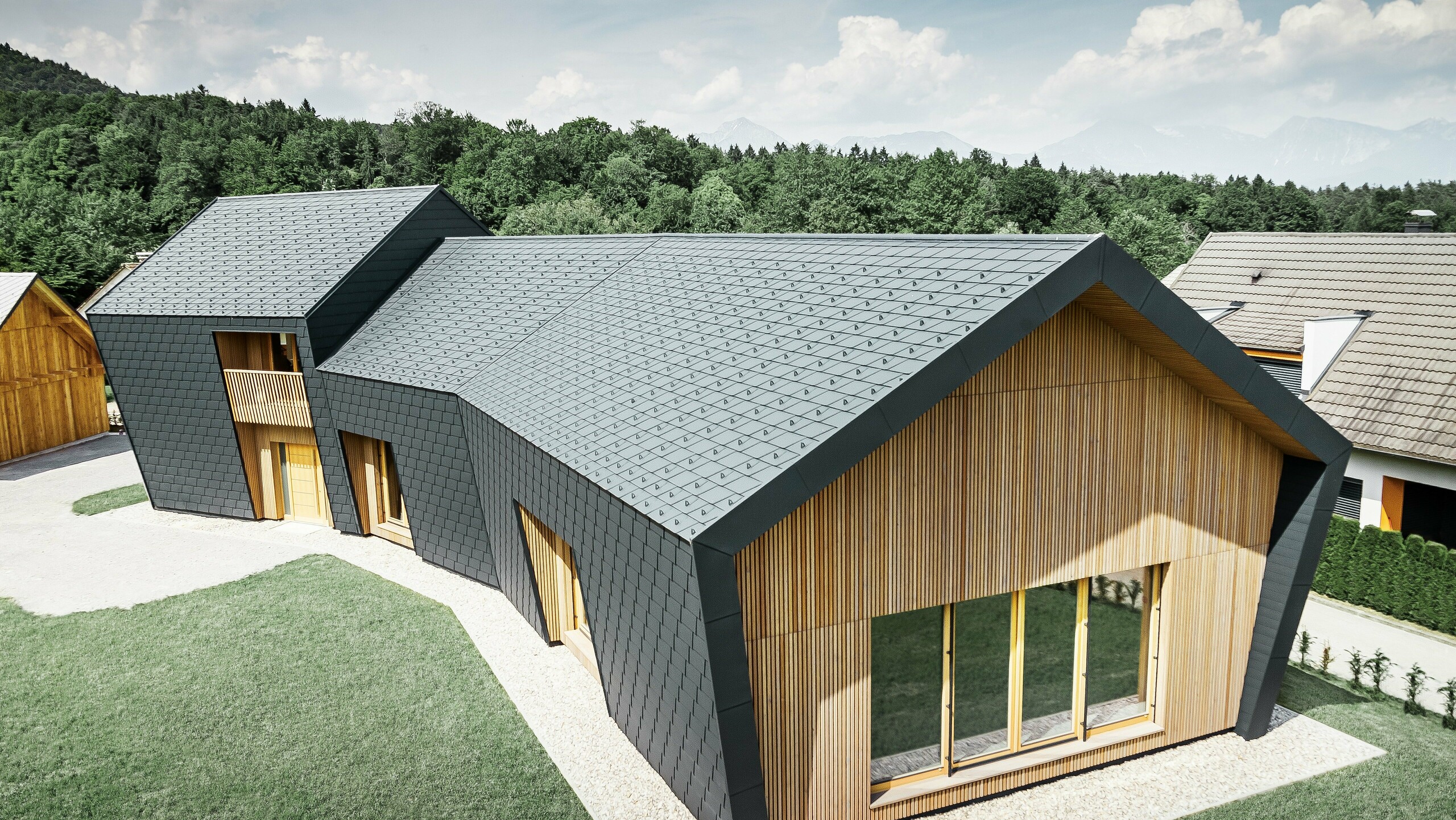 Suprafețe de acoperiș și fațadă mari, acoperite cu șindrila DS.19 în culoarea P.10 antracit, pe partea frontală, fațada a fost placată cu lemn
