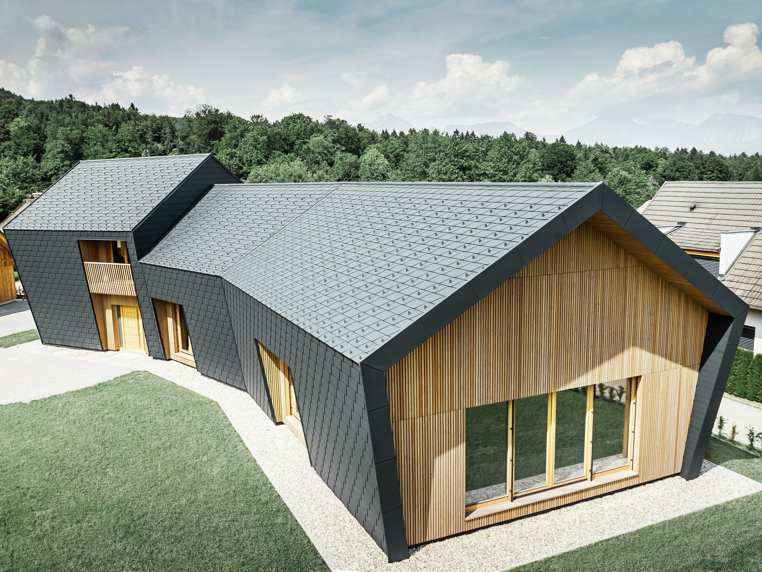 Suprafețe de acoperiș și fațadă mari, acoperite cu șindrila DS.19 în culoarea P.10 antracit, pe partea frontală, fațada a fost placată cu lemn