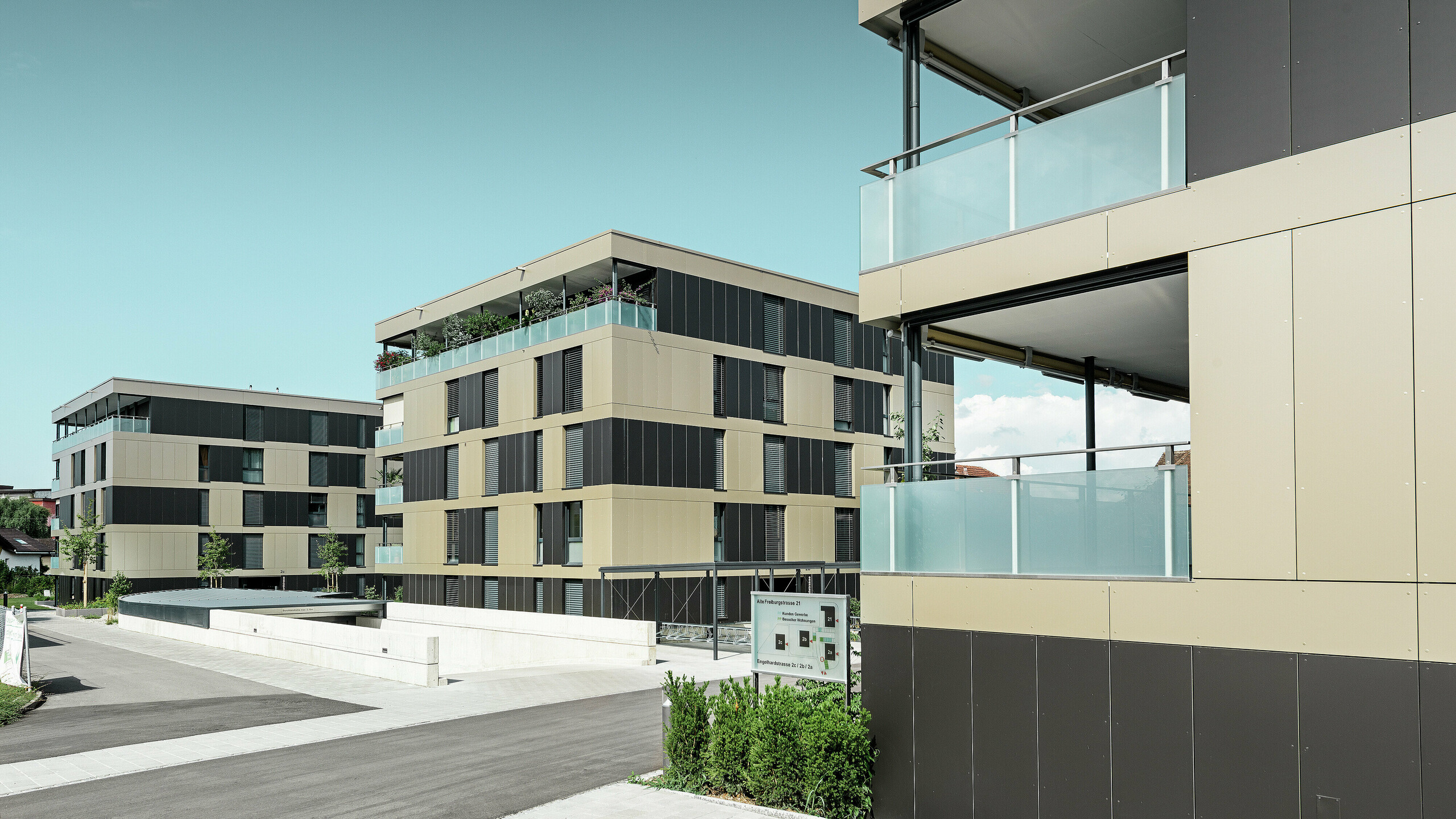 Die moderne Wohnanlage in Murten (CH) beeindruckt mit einer PREFA Fassade, die mit Aluminium Verbundplatten in den Farben Bronze und Schwarzgrau ausgestattet wurde. Diese Kombination sorgt für ein zeitloses und elegantes Erscheinungsbild. Die langlebigen Platten bieten nicht nur ästhetische Vorteile, sondern auch einen hervorragenden Witterungsschutz, der die Fassade funktionell und attraktiv macht.