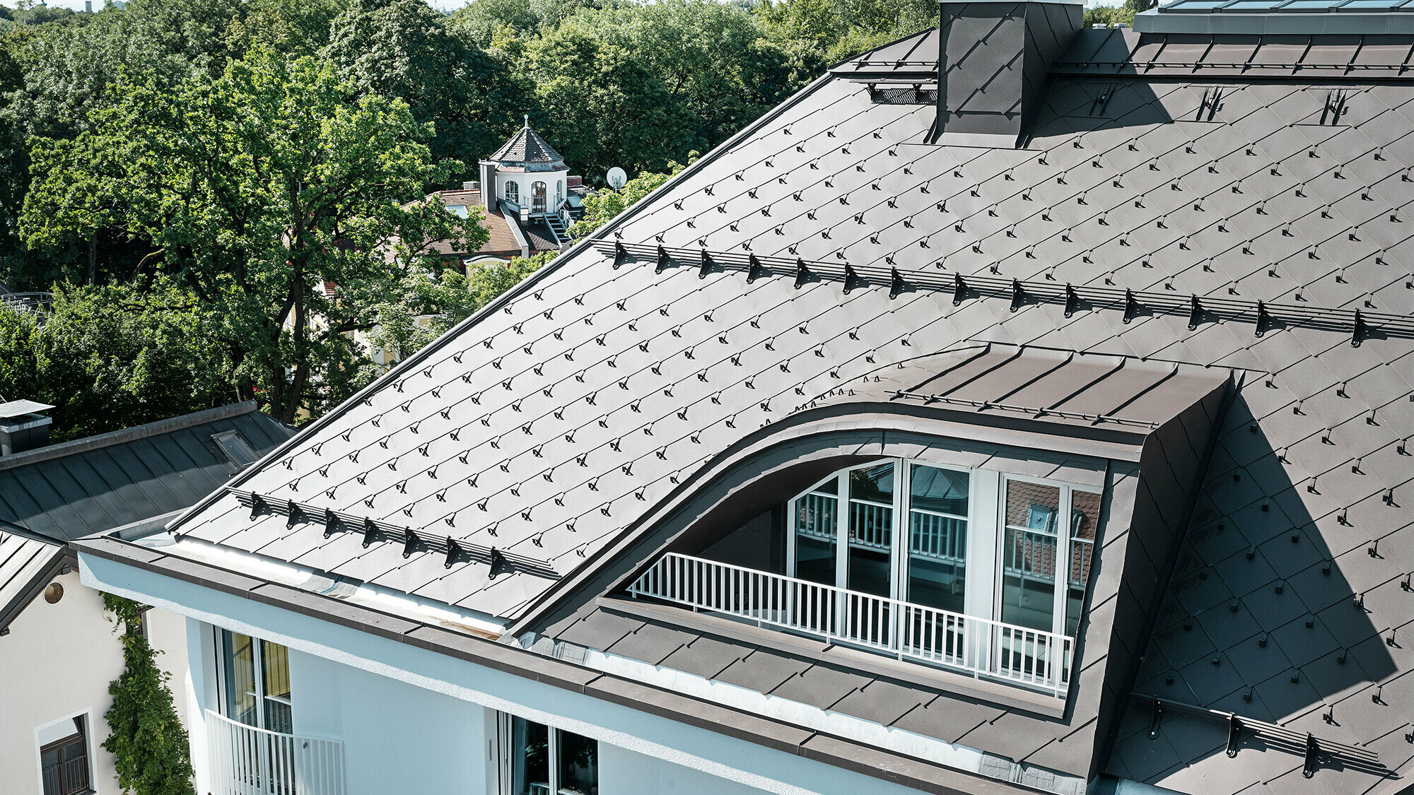 Casă multifamilială cu solzi romboidali 44 × 44 de la PREFA în culoarea maro cu cârlige parazăpadă și opritoare de zăpadă