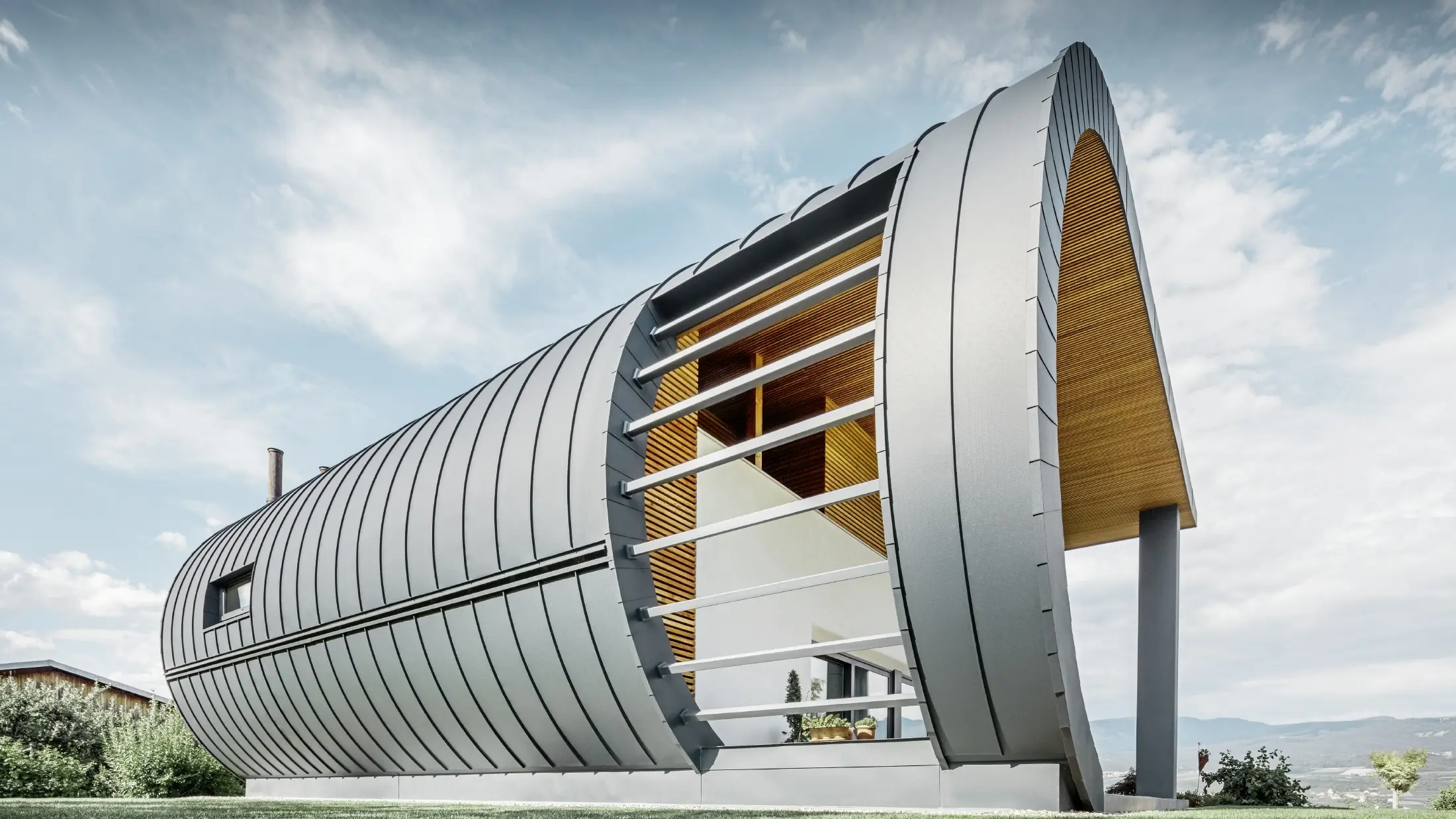 Casă monofamilială neobișnuită cu fațadă Prefalz rotunjită în culoarea antracit.